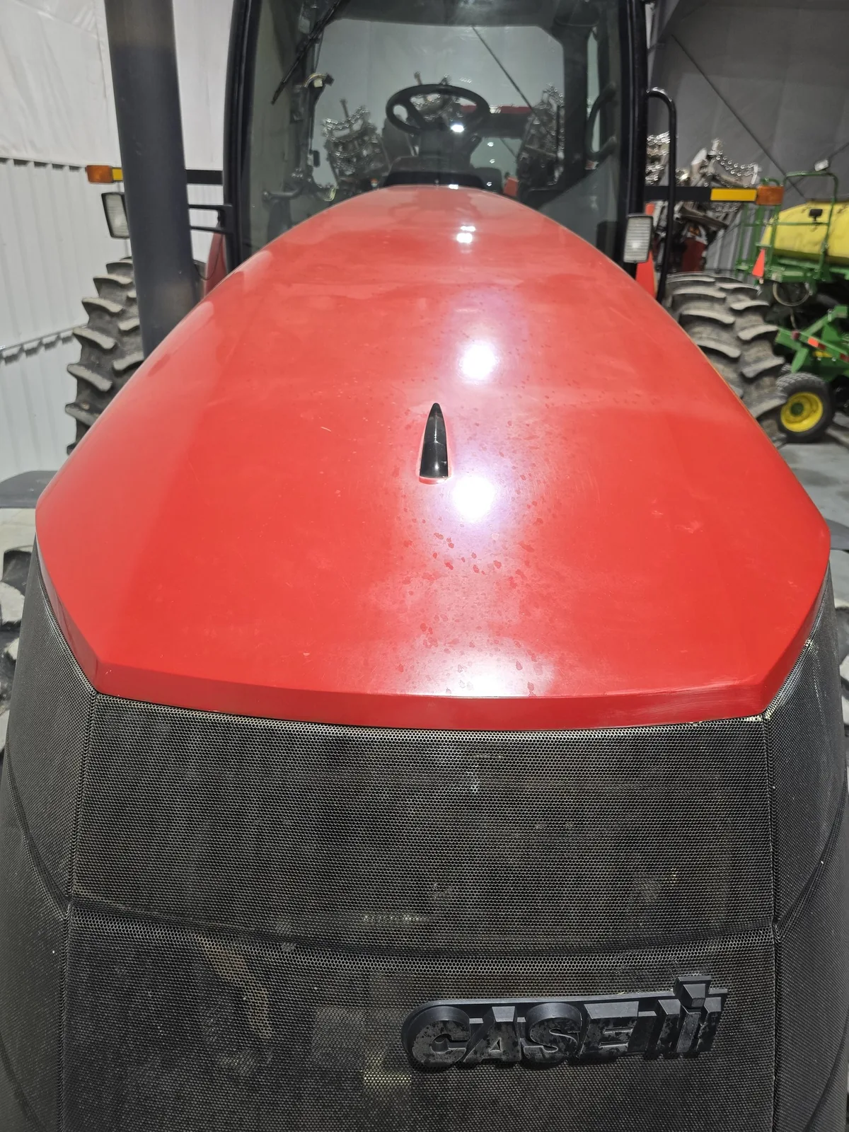 Faded, oxidized red paint on the Case IH Magnum 275 hood before correction